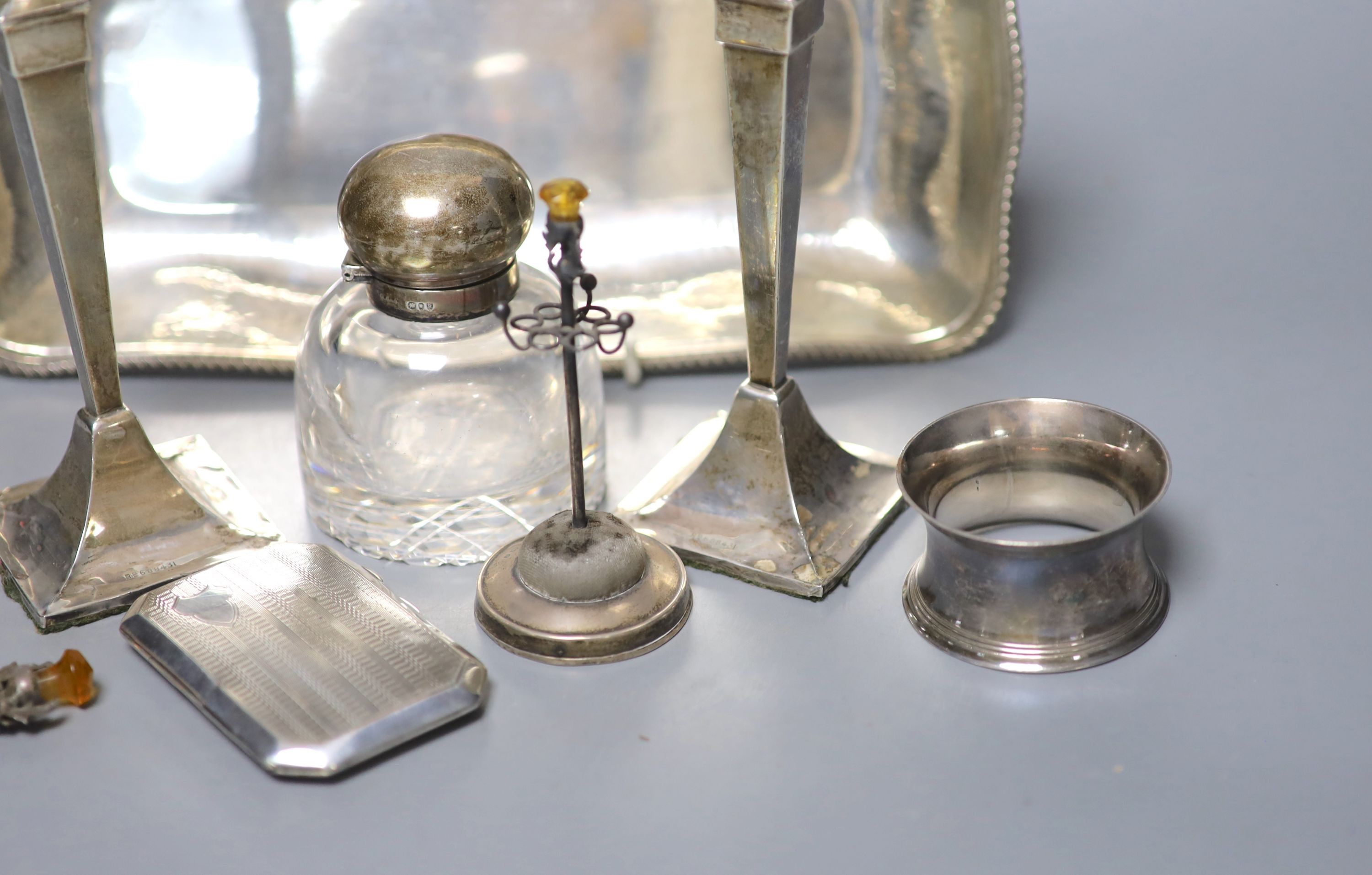 A pair of George V silver candlesticks (a.f.) and other small silver including a hat pin stand, cigarette case and 800 dish etc. and a pair of plated napkin rings.